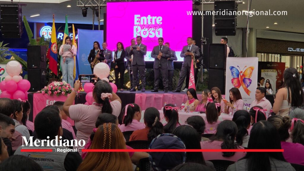 Público reunido frente a una tarima con músicos, una presentadora y decoración rosada durante el lanzamiento del Mes Rosa en Popayán.