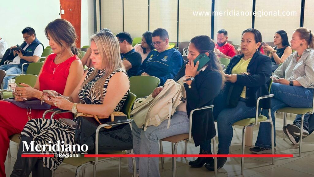 Varias personas permanecen sentadas en un auditorio durante una reunión sobre el PGIRS de Popayán; algunas consultan sus teléfonos celulares.
