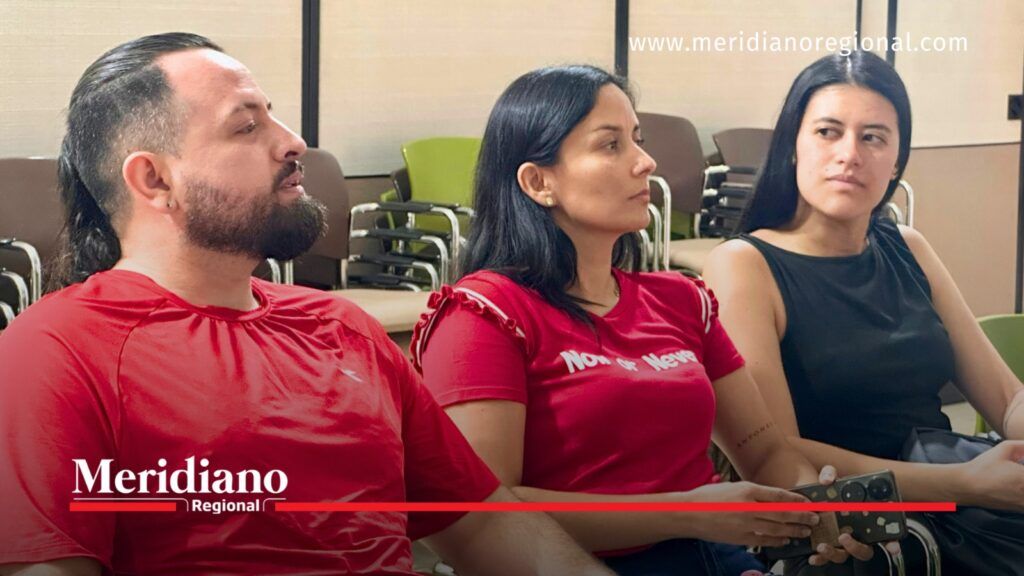 Tres asistentes, dos mujeres y un hombre, permanecen sentados durante una reunión sobre la actualización del PGIRS en Popayán.