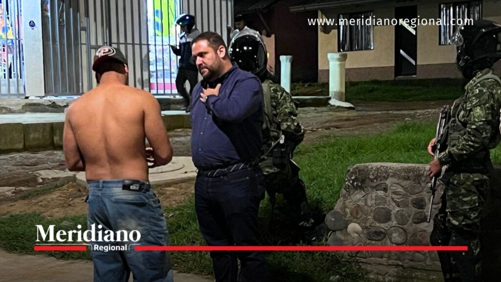 Funcionario conversa con un ciudadano durante un operativo de seguridad acompañado por uniformados en Popayán, Cauca.